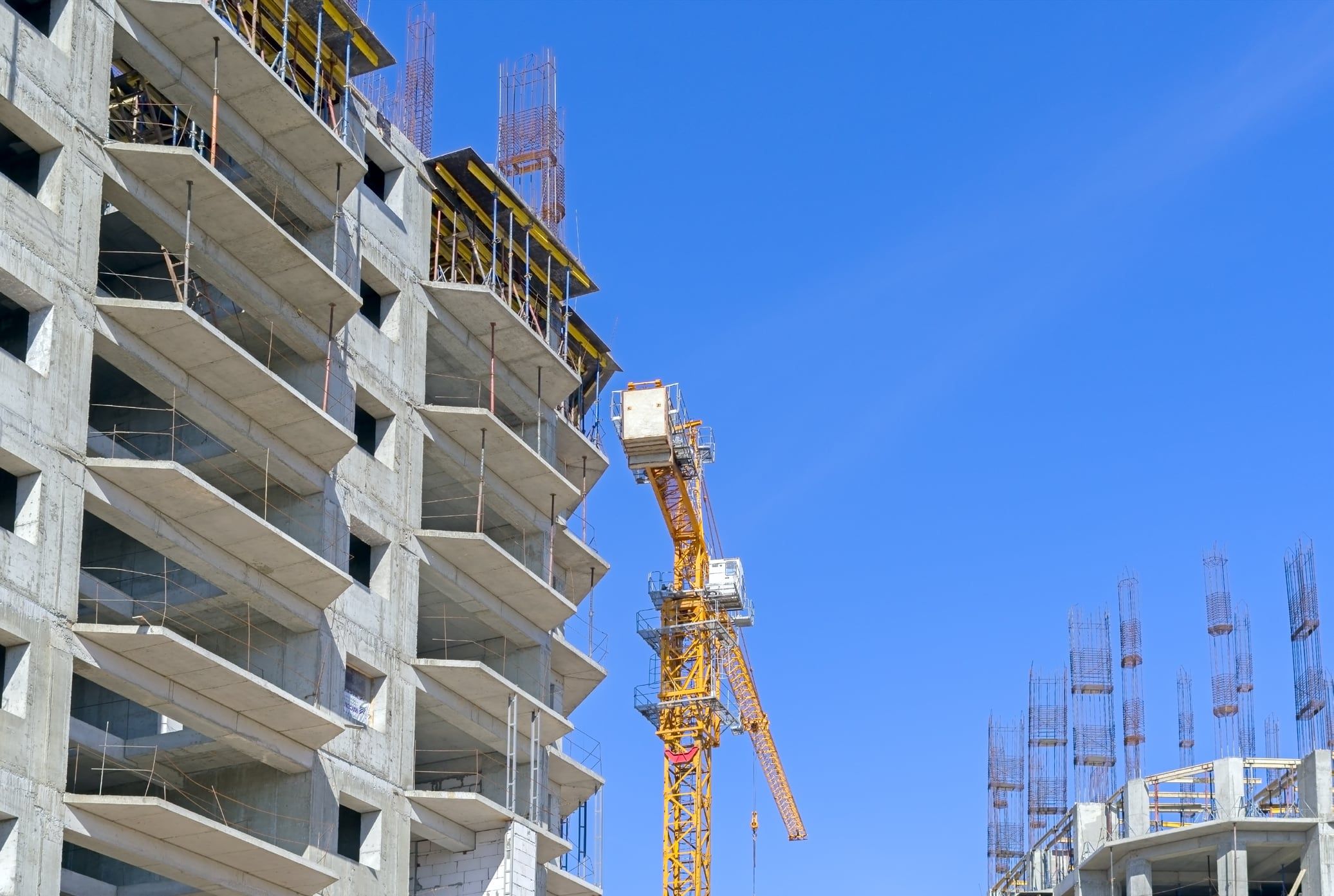 Tower crane beside a concrete-framed building under construction