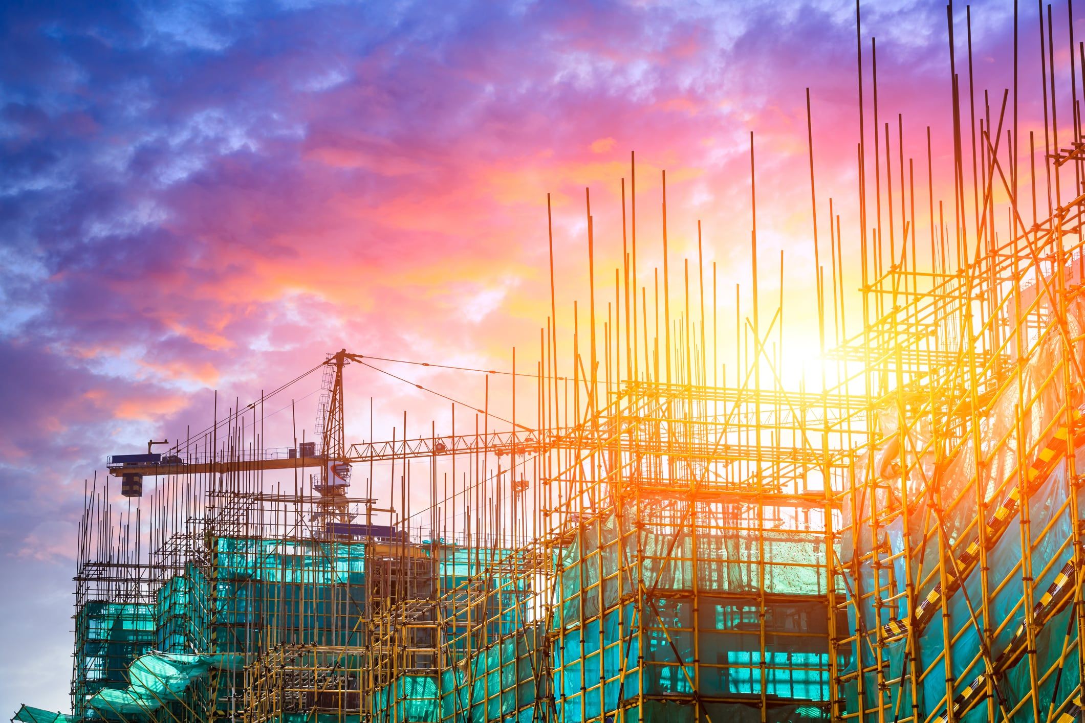 Construction site with reinforcement and scaffolding at sunset